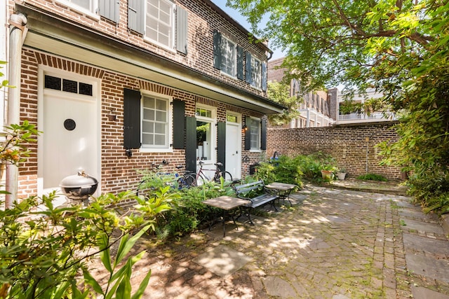 property entrance featuring fence and brick siding
