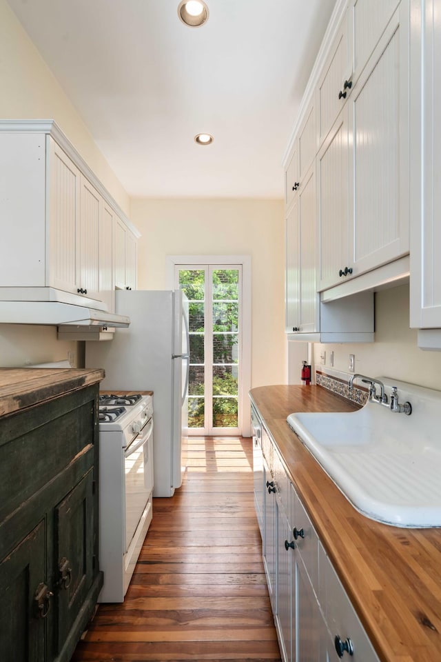 kitchen with a sink, dark wood-type flooring, butcher block countertops, gas range gas stove, and recessed lighting