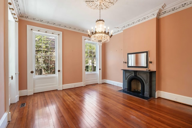 unfurnished living room with crown molding, a chandelier, baseboards, and hardwood / wood-style flooring