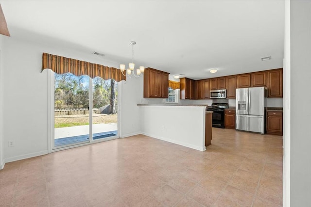 kitchen with stainless steel appliances, kitchen peninsula, a notable chandelier, and decorative light fixtures