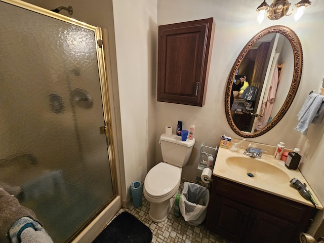 bathroom featuring toilet, a stall shower, and vanity