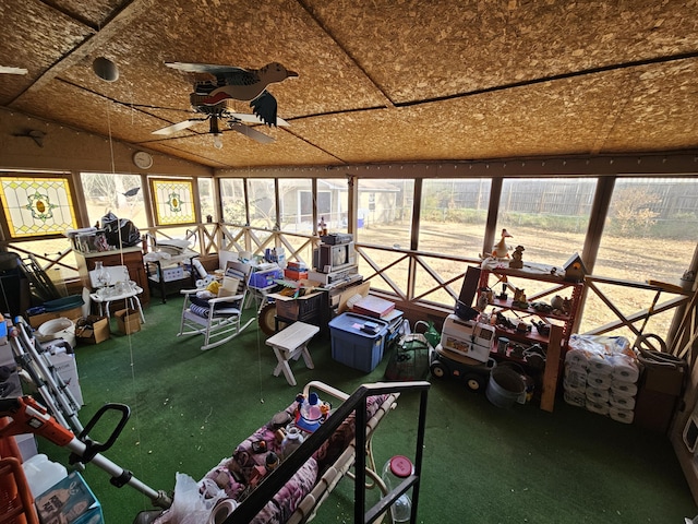 unfurnished sunroom with ceiling fan, vaulted ceiling, and a wealth of natural light