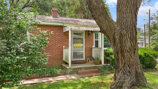 1549 N Avalon Cir, Charleston, SC 29407 - entrance to property featuring brick siding, a chimney, and a shingled roof