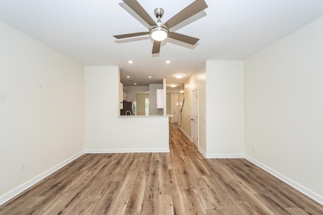 unfurnished living room with a ceiling fan, light wood-type flooring, baseboards, and recessed lighting