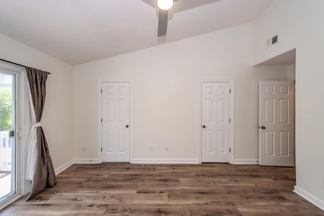spare room with ceiling fan, wood finished floors, baseboards, and high vaulted ceiling