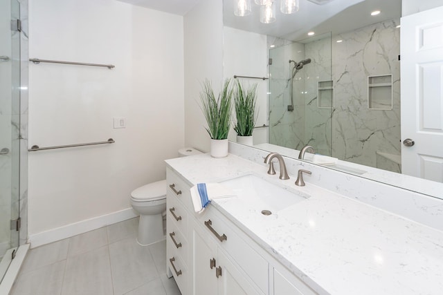 bathroom with a marble finish shower, tile patterned floors, baseboards, toilet, and vanity