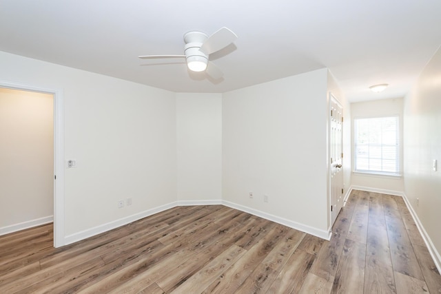 unfurnished room featuring wood finished floors, a ceiling fan, and baseboards