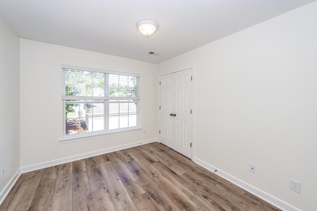 spare room with wood finished floors and baseboards