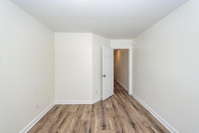 empty room featuring wood finished floors and baseboards