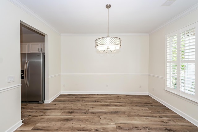 unfurnished dining area featuring wood finished floors, plenty of natural light, ornamental molding, and a chandelier
