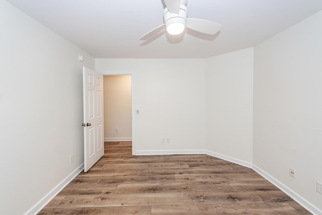 spare room with wood finished floors, ceiling fan, and baseboards