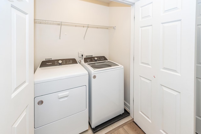 clothes washing area with washing machine and dryer