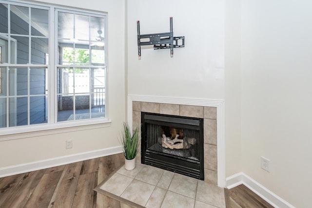 detailed view of wood finished floors, a fireplace, and baseboards