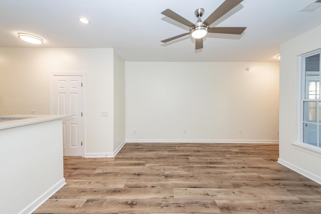 empty room featuring ceiling fan, light wood-style flooring, recessed lighting, and baseboards