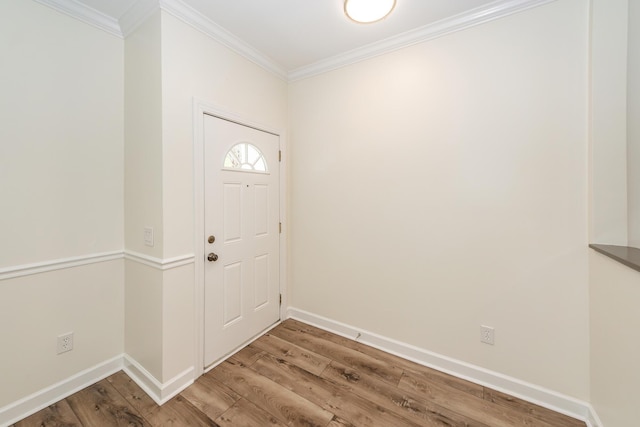entrance foyer with ornamental molding, light wood-style floors, and baseboards