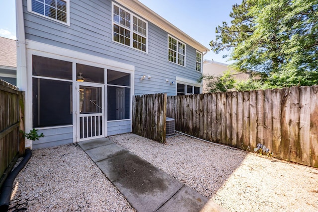 back of property with a sunroom, a fenced backyard, and cooling unit