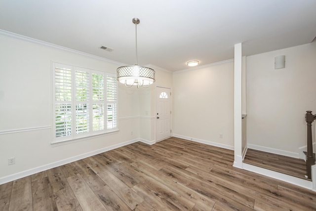 entryway with crown molding, a chandelier, wood finished floors, baseboards, and stairway