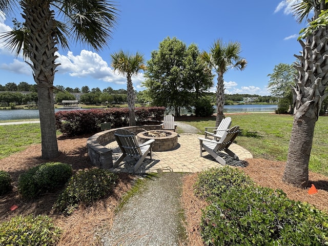 view of patio with a fire pit and a water view