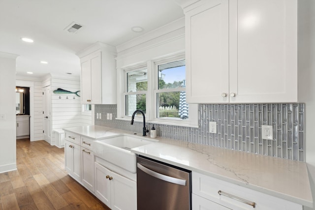 kitchen featuring sink, light hardwood / wood-style flooring, tasteful backsplash, white cabinets, and stainless steel dishwasher