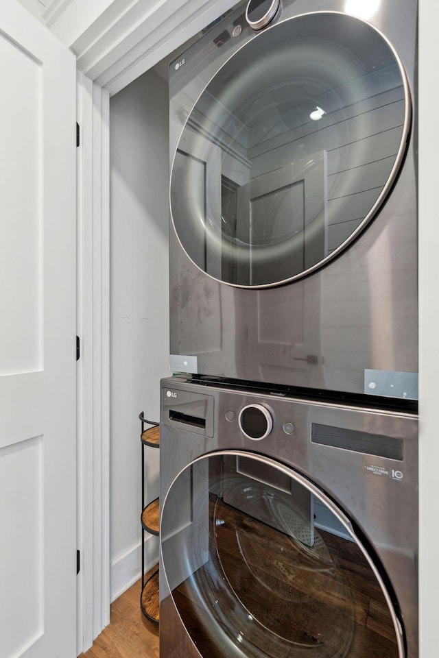 clothes washing area with light hardwood / wood-style floors and stacked washing maching and dryer