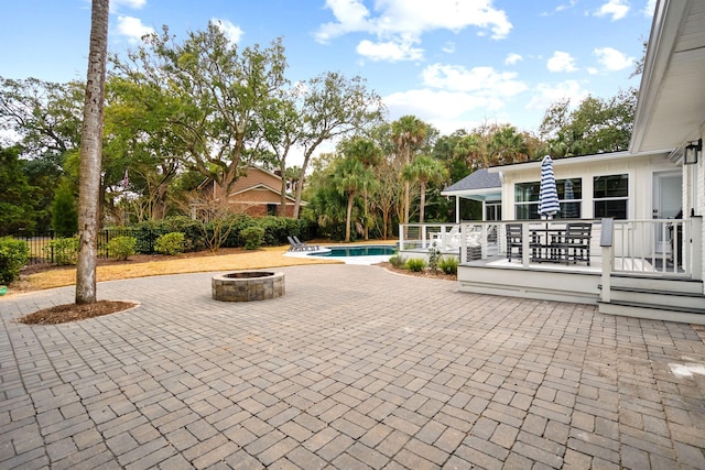 view of pool with a wooden deck, a fire pit, and a patio