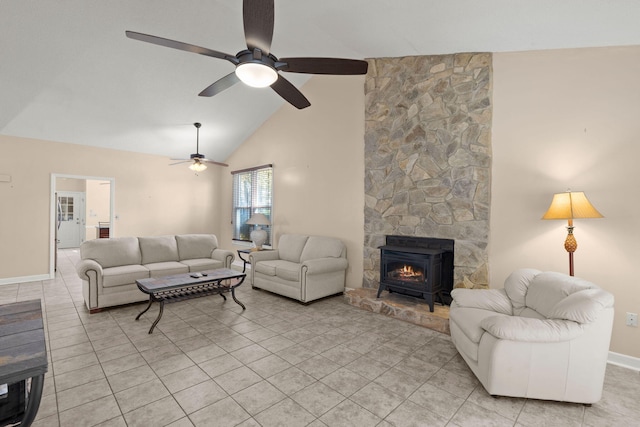 living room with ceiling fan, light tile patterned floors, high vaulted ceiling, and a wood stove