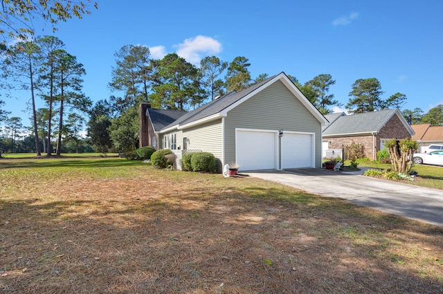 view of side of home featuring a lawn and a garage