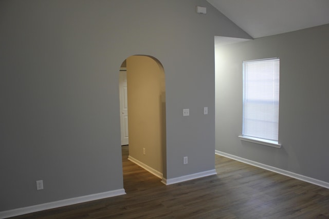 spare room featuring dark hardwood / wood-style flooring and vaulted ceiling