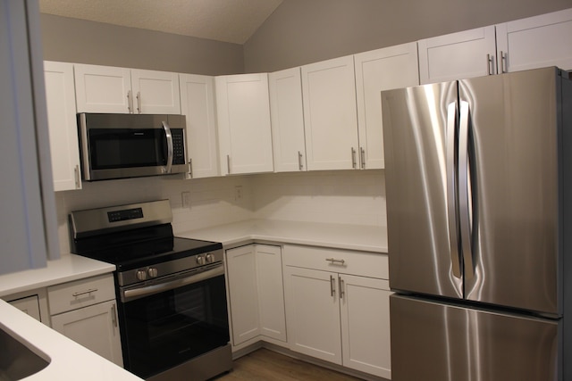 kitchen with white cabinets, decorative backsplash, and appliances with stainless steel finishes