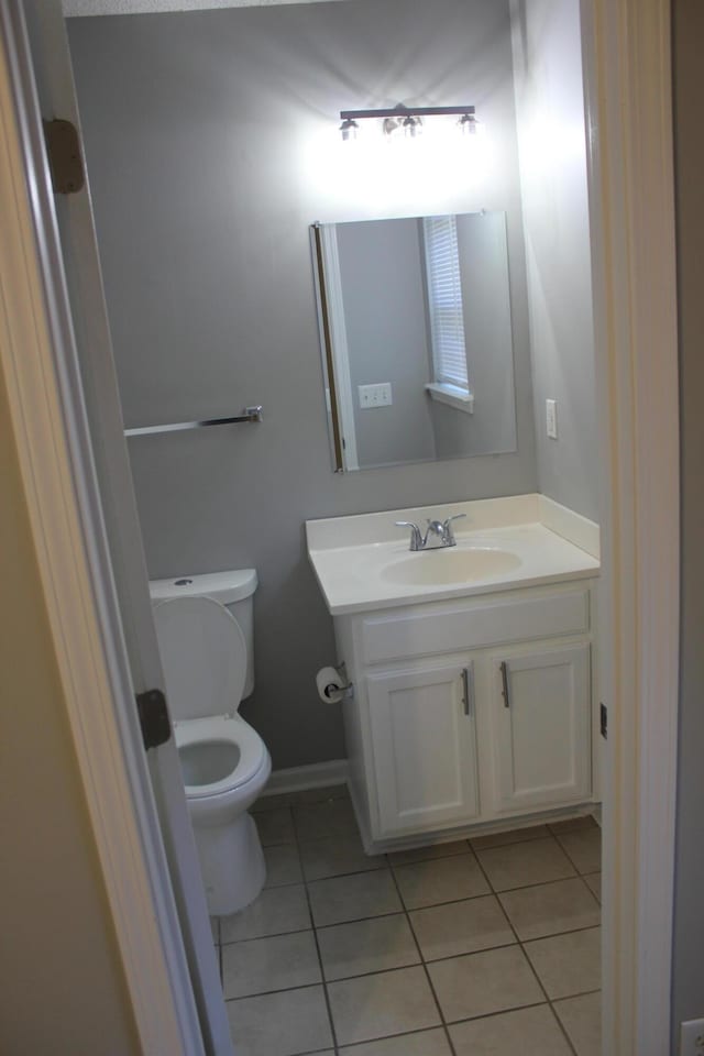 bathroom featuring toilet, tile patterned flooring, and vanity