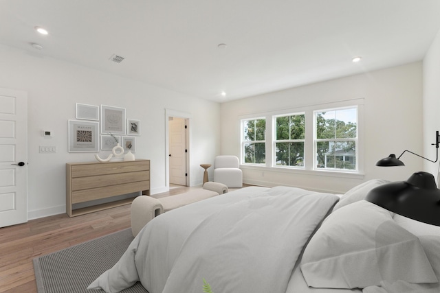 bedroom with recessed lighting, light wood-type flooring, baseboards, and visible vents