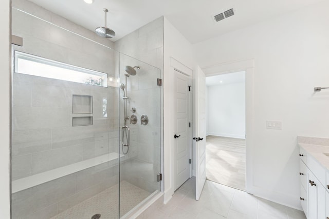 bathroom with visible vents, a shower stall, tile patterned flooring, baseboards, and vanity