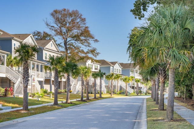 view of road featuring curbs, stairway, and a residential view