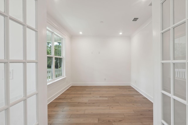 unfurnished room featuring visible vents, baseboards, recessed lighting, light wood-style floors, and crown molding