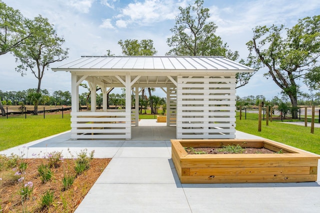 view of community with a gazebo, a lawn, and fence