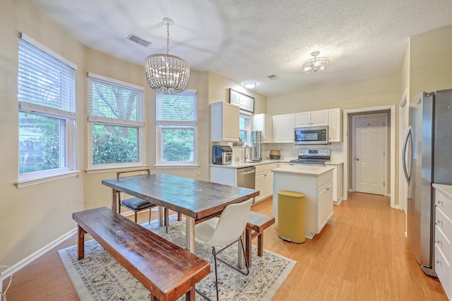 1972 Gray Battery Ct, Mount Pleasant, SC 29464 - kitchen with appliances with stainless steel finishes, a chandelier, a textured ceiling, light countertops, and a center island