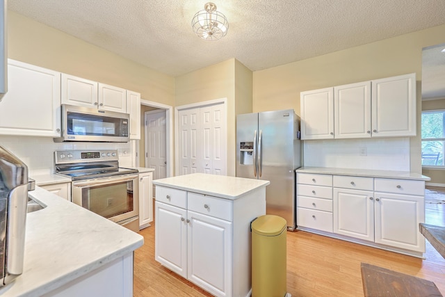 1972 Gray Battery Ct, Mount Pleasant, SC 29464 - kitchen featuring appliances with stainless steel finishes, light wood finished floors, white cabinets, tasteful backsplash, and a textured ceiling