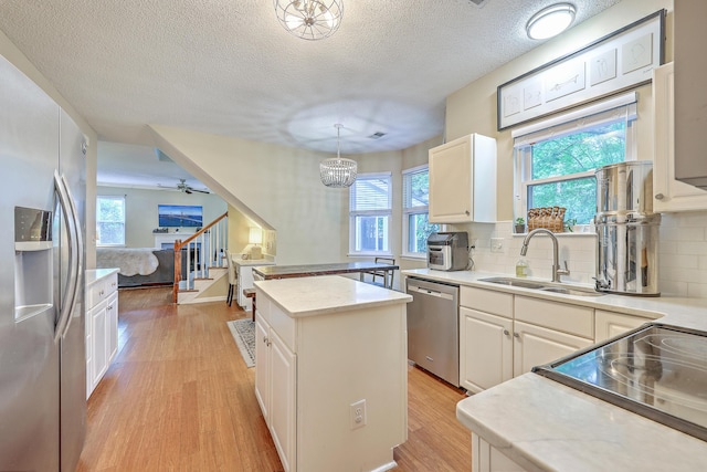 1972 Gray Battery Ct, Mount Pleasant, SC 29464 - kitchen with appliances with stainless steel finishes, light wood-style flooring, a center island, plenty of natural light, and a textured ceiling