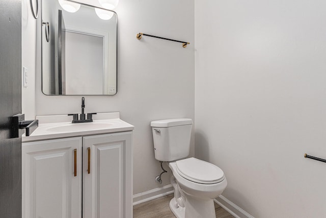 bathroom with vanity, hardwood / wood-style flooring, and toilet