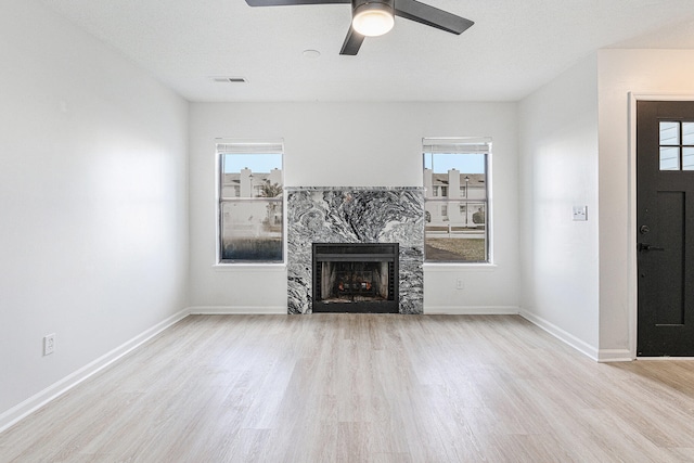 unfurnished living room with plenty of natural light, light hardwood / wood-style floors, and a fireplace