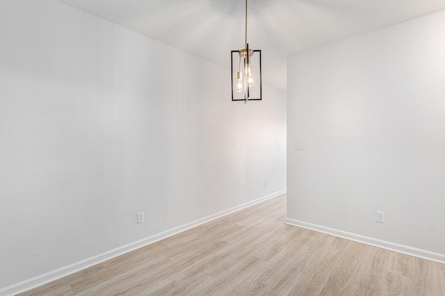 empty room with a textured ceiling and light wood-type flooring