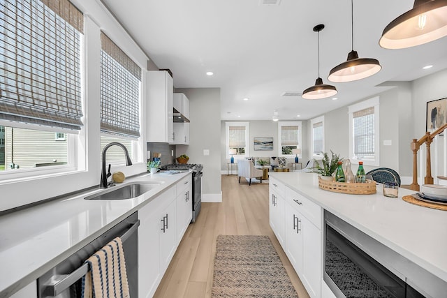 101 Hanover St, Charleston, SC 29403 - kitchen featuring appliances with stainless steel finishes, hanging light fixtures, white cabinets, light wood finished floors, and light countertops