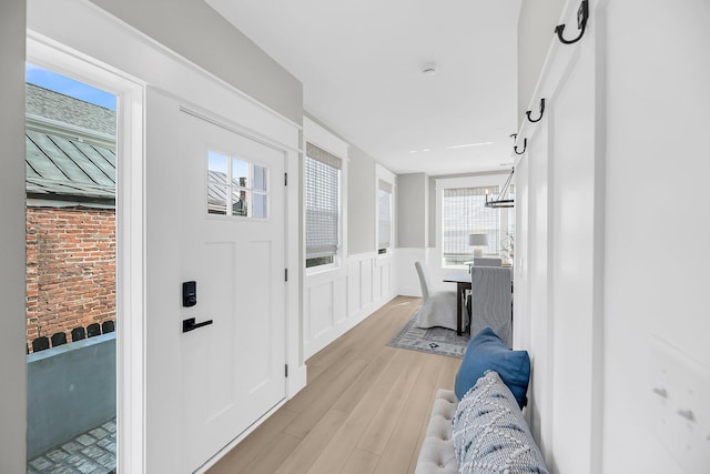 101 Hanover St, Charleston, SC 29403 - foyer with light wood finished floors, wainscoting, a decorative wall, and a chandelier