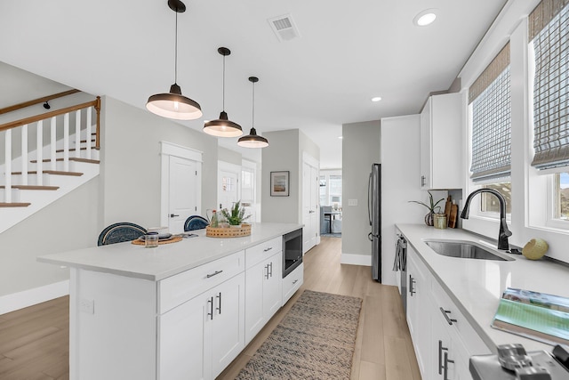 101 Hanover St, Charleston, SC 29403 - kitchen with built in microwave, a center island, light countertops, light wood-style flooring, and recessed lighting