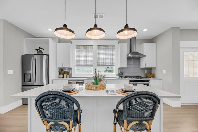 101 Hanover St, Charleston, SC 29403 - kitchen with wall chimney range hood, appliances with stainless steel finishes, a breakfast bar, light wood-style floors, and recessed lighting