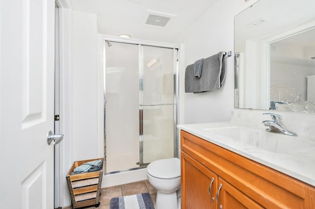 bathroom with tile patterned floors, vanity, an enclosed shower, and toilet