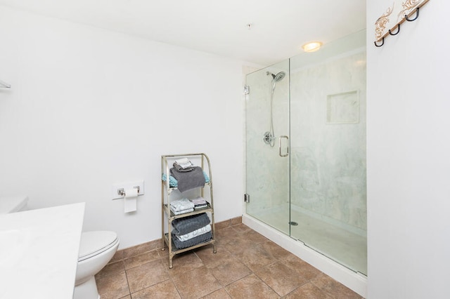 bathroom featuring tile patterned floors, toilet, and a shower with door