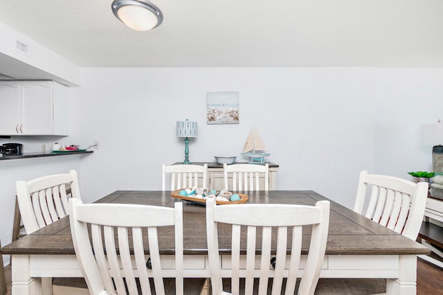 dining space with dark wood-type flooring