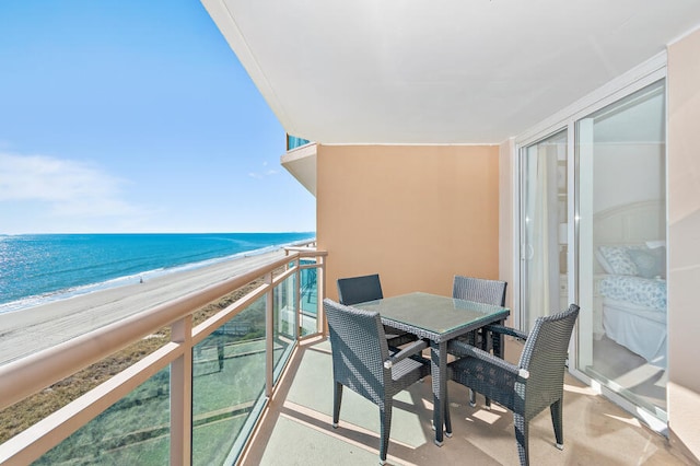 balcony with a water view and a view of the beach