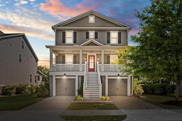 beach home featuring stairway, a porch, a garage, and driveway